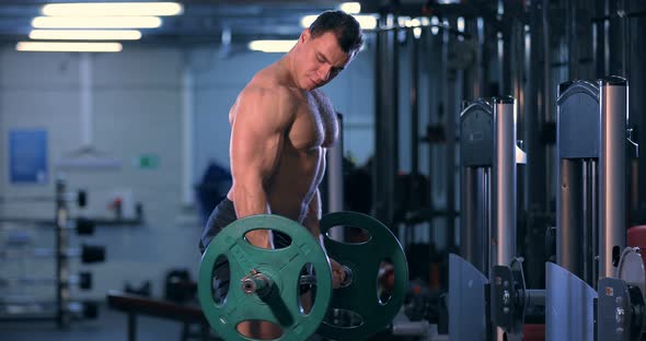 Bodybuilder Doing an Exercise with a Barbell in the Gym alt