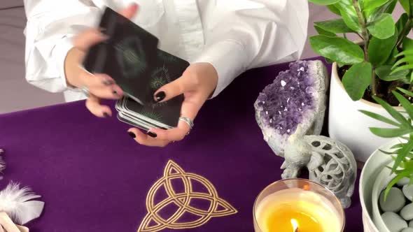 Close up footage of two hands shuffling and adjusting tarot cards