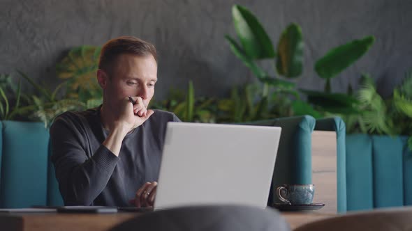Thoughtful Serious Young Man Student Writer Sit at Home Office Desk with Laptop Thinking of alt