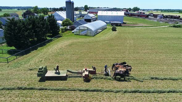 Aerial View of An Amish Farmers Harvesting There Crops With Five Horses Pulling There Baler alt