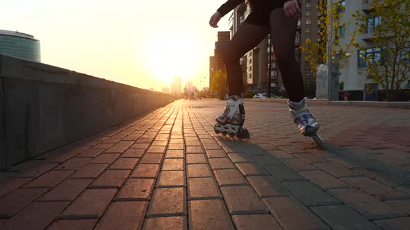 Slender Legs of a Girl Figure Skater in Roller Skates Ride on the Cobblestones.