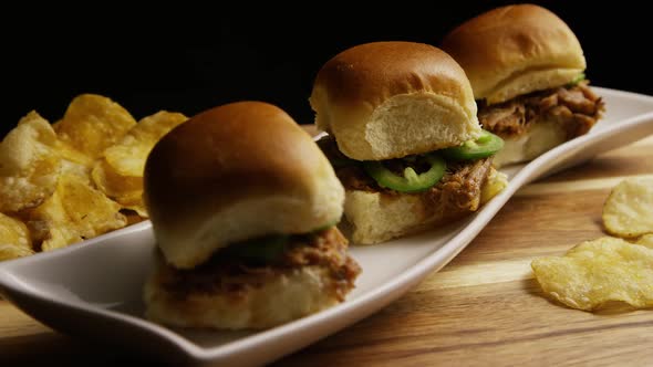 Rotating shot of delicious pulled pork sliders - BBQ  alt
