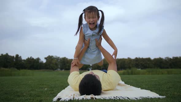 Playful Father Lifting Up Cute Daughter Outdoors