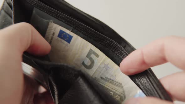 A Man Shows a 5 Euro Bill Inside His Wallet