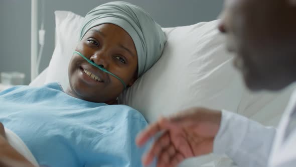 Female Patient Chatting with Doctor in Hospital Ward alt
