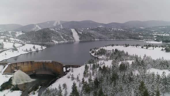 Dam Spilling Opened Lake Winter Snow Aerial Drone Shot 01