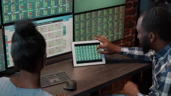 African American Man and Woman Monitoring Exchange Market Graphs alt