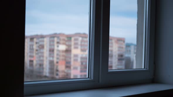 From Day To Night View Through the Window at the Lights the Windows in High-rise Buildings alt