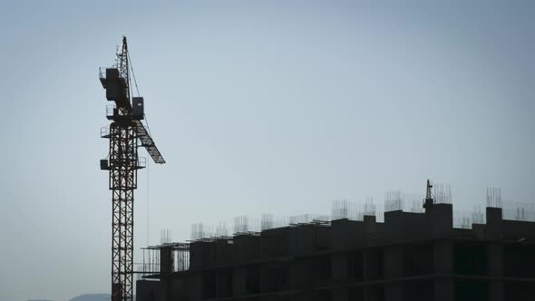 Tower Crane on a Construction Site Lifts a Load at High-rise Building. Timelapse. alt