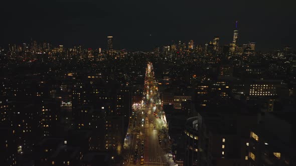 Aerial Panoramic Footage of Illuminated Street and Surrounding Buildings at Night alt