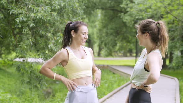 Brunette Women Rest After Jogging in Green Public Garden