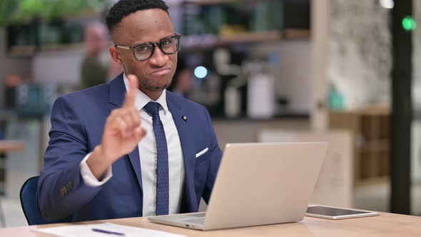 African Businessman with Laptop Showing No Sign in Office  alt