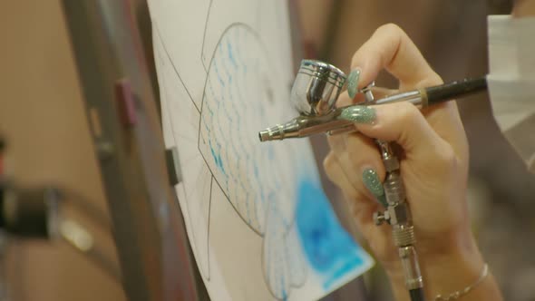 Woman Artist Learns to Paint with Airbrush with Acrylic Dye Paper and Easel alt