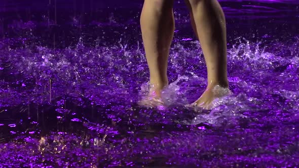 Young Woman Enjoying a Salsa Dance in the Pouring Rain. Bare Feet Create Splashes of Water in Slow alt