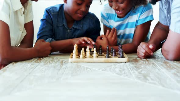 Family playing chess together at home in the living room alt