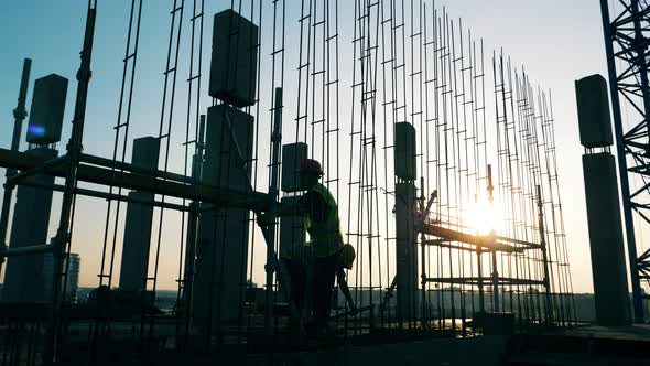 Engineers Work at a Building Site, Installing Poles. alt