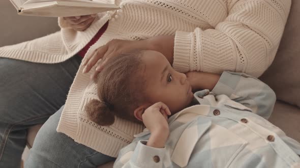 Girl Lying on Lap of Parent alt