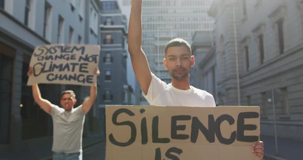 Two mixed race men on a protest march holding placards raising hands and shouting alt