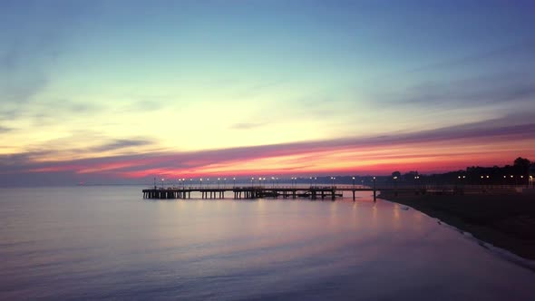 Early morning on the beach just before the sunrise. Drone footage. Orange and purple sky. Relaxing s alt