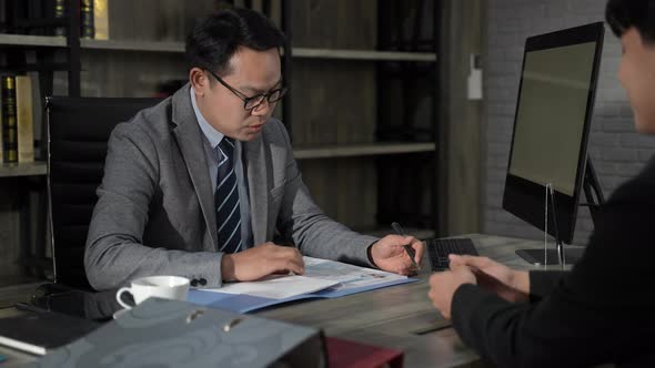 Executives talking to business people at their desks in the office