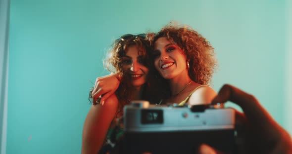 Two girls dancing and posing for a picture in confetti alt
