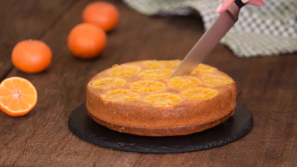 Female Hands Cuts Upside Down Tangerine Cake