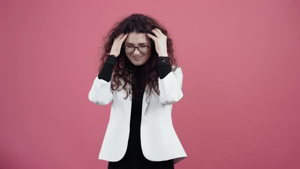 The Young Woman with Curly Hair Has Migraines Massaging with Her Hands alt
