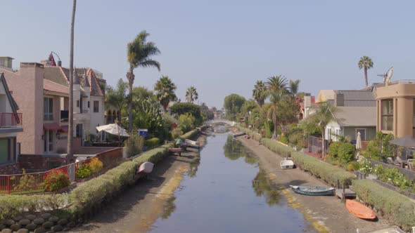 Dry canal amidst houses in city alt