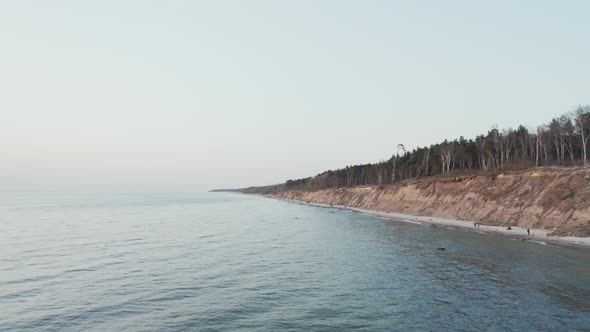 AERIAL: People Walking on a The Dutchman's Cap Beach in Klaipeda on Lovely Spring Evening alt