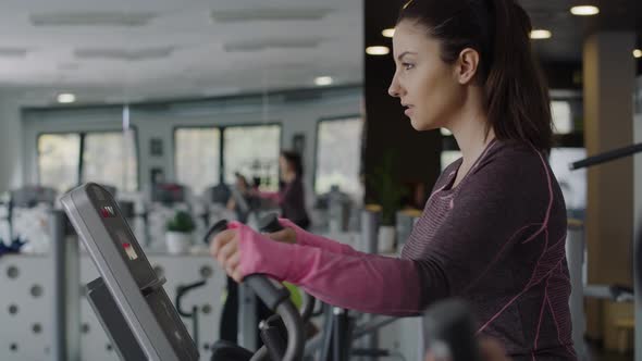 Handheld view of young woman exercising in the gym.  Shot with RED helium camera in 8K alt