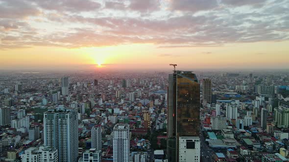 Brilliant Sunset Over Phnom Penh Skyline With View Of Golden Tower - aerial alt