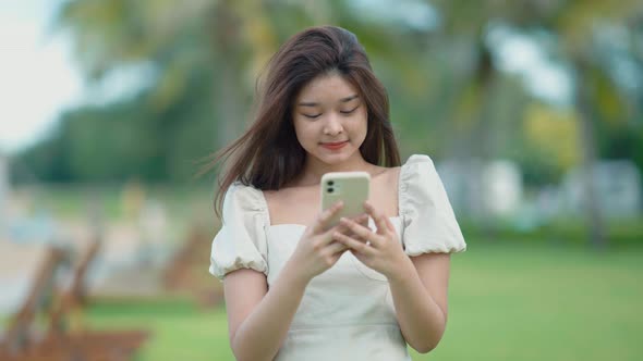 Asian cute girl She uses her cell phone to talk to her friends with fun.