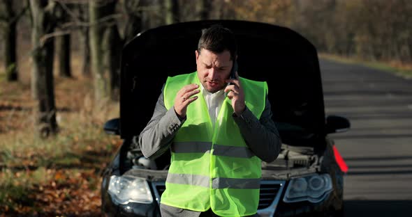 Young Sad Businessman Using Cell Phone By Brokendown Car at Countryside alt