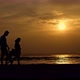Silhouette a Pregnant Woman with Her Family Walking Along the Seashore Hair Blowing in the Wind - VideoHive Item for Sale