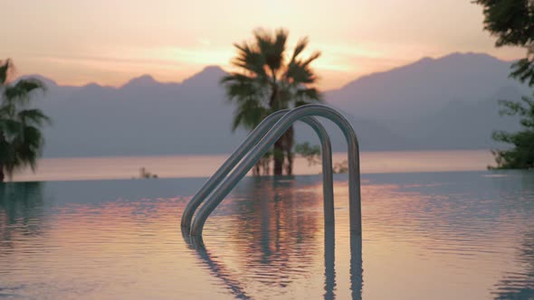 A closeup of an open swimming pool railing against the evening scenery alt