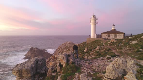 Photographer drone aerial view photographing a sea landscape view of Cape Tourinan Lighthouse, Spain alt