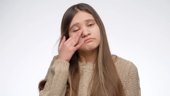 Portrait of Upset Girl Rubbing Off Tears with Hand and Rolling Up Eyes alt