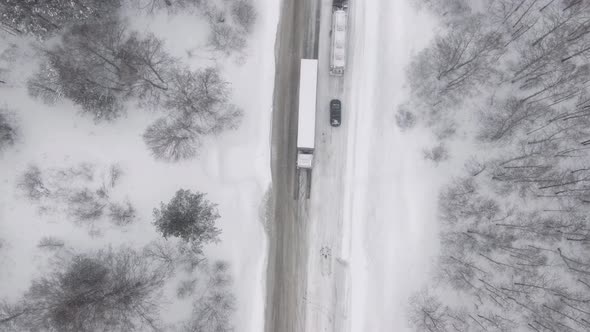 A Truck is Skidding Trying to Climb a Snow Road Uphill During a Snow Storm