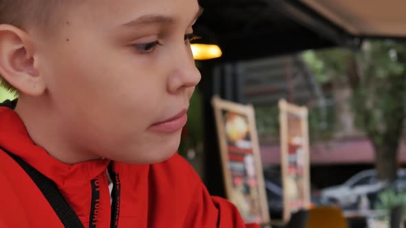 a Teenage Girl with a Short Hairstyle Hungry Bites and Chews Doner Kebab in Pita Bread alt