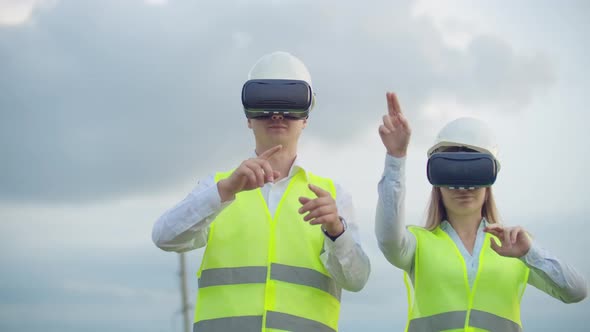 A Man and a Woman Engineer in VR Glasses Control the Power Distribution of Electric Networks and the alt