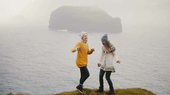 Two Crazy Happy Woman Standing on the Shore of a Sea and Dancing Together Tourists Having Fun in alt