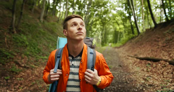 Man with Backpack Walking in Forest