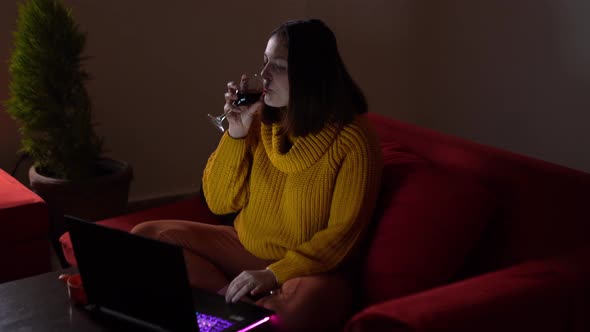 Cheerful Woman Drinking Wine and Chatting Online