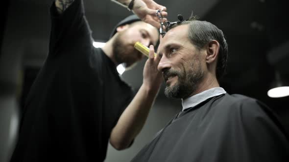 Haircut of Dark Haired Bearded Man in Barbershop