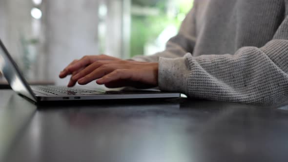 Closeup a woman working and typing on laptop computer keyboard on the table