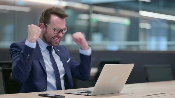 Middle Aged Businessman with Laptop Celebrating Success alt