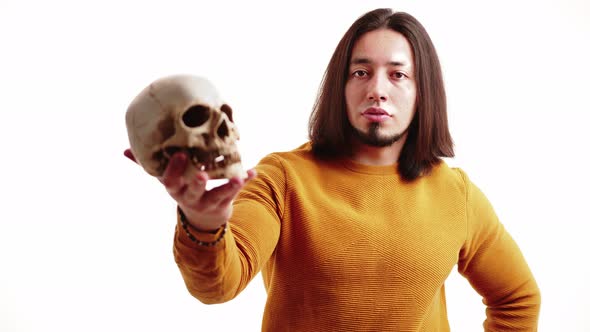 Studio Portrait of a Skeleton's Skull Model Held By Caucasian Middleaged Muscular Brunet Man Wearing alt