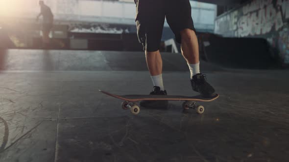 Active Man Practicing Skateboard at Skate Park with Graffiti on Wall alt