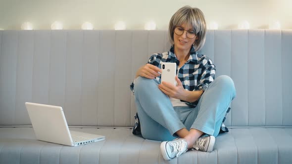 A Beautiful Grayhaired Middleaged Woman with Someone is Having Fun Talking and Laughing on the Phone