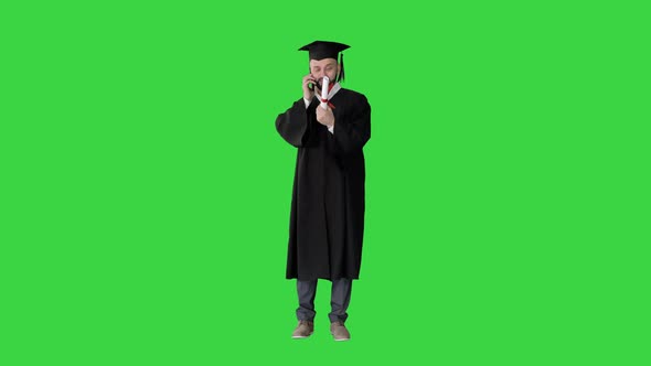 Happy Graduated Young Man in Cap and Gown Talking with Parent on Mobile Phone on a Green Screen alt